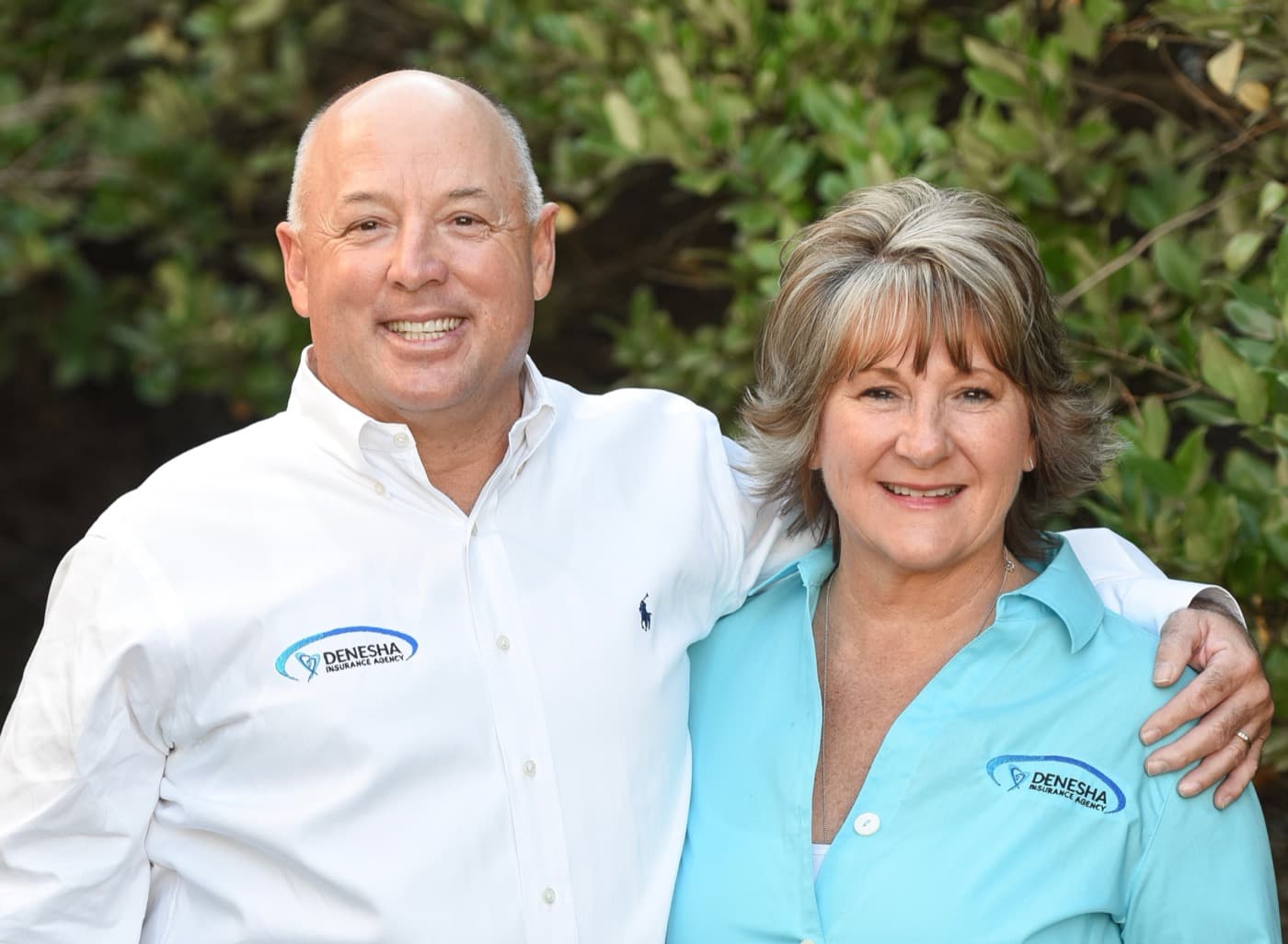 Terry and Debbie Denesha in branded Denesha Insurance shirts